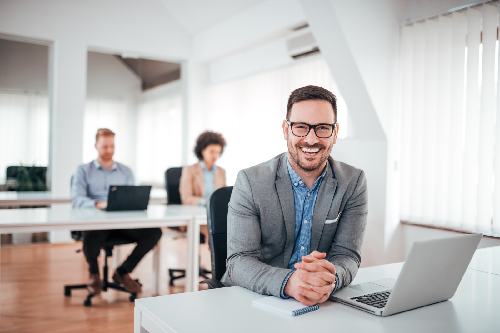 Business owner on a call at his laptop in a bright office