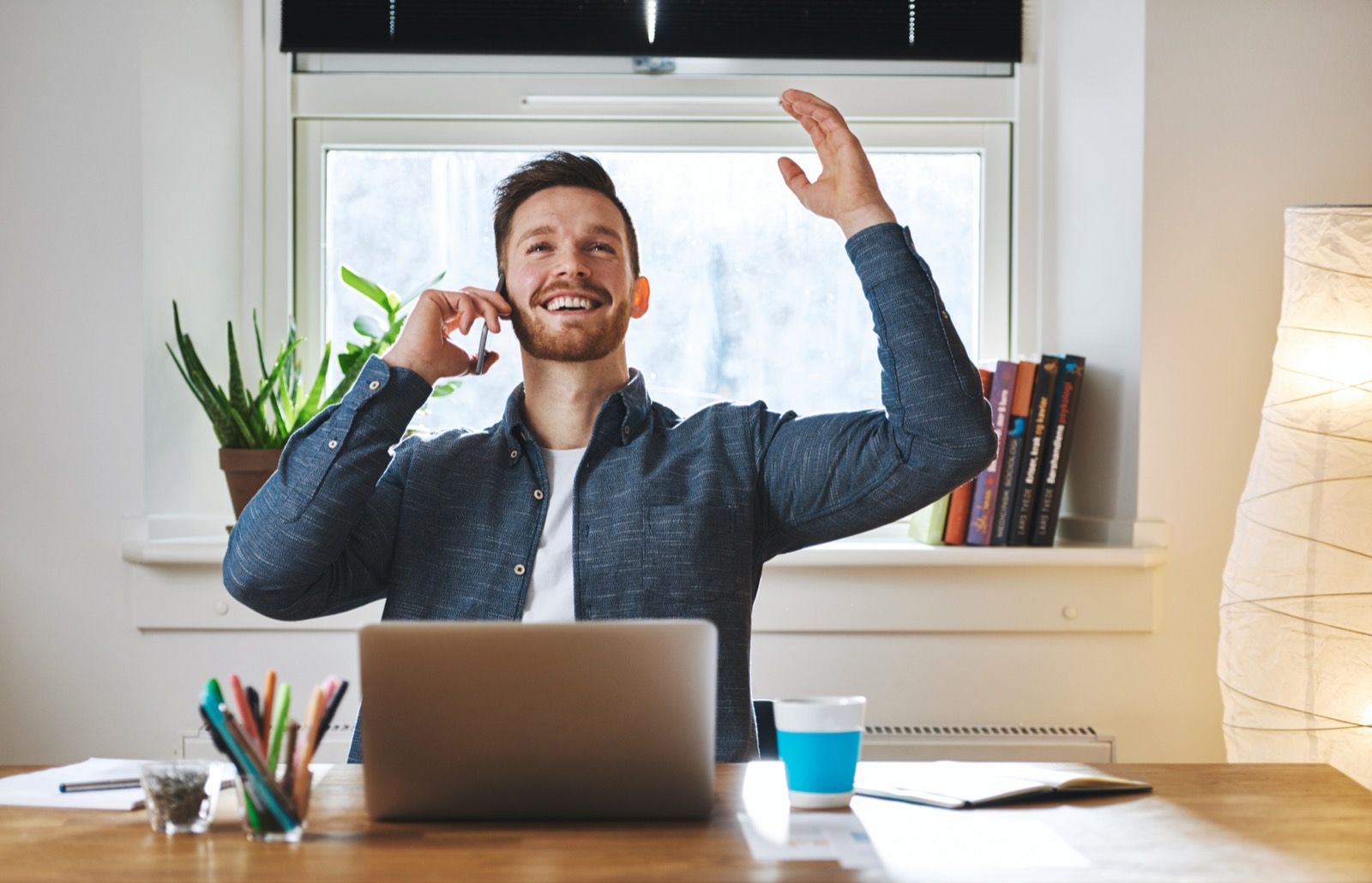 Happy business owner on a call at his laptop
