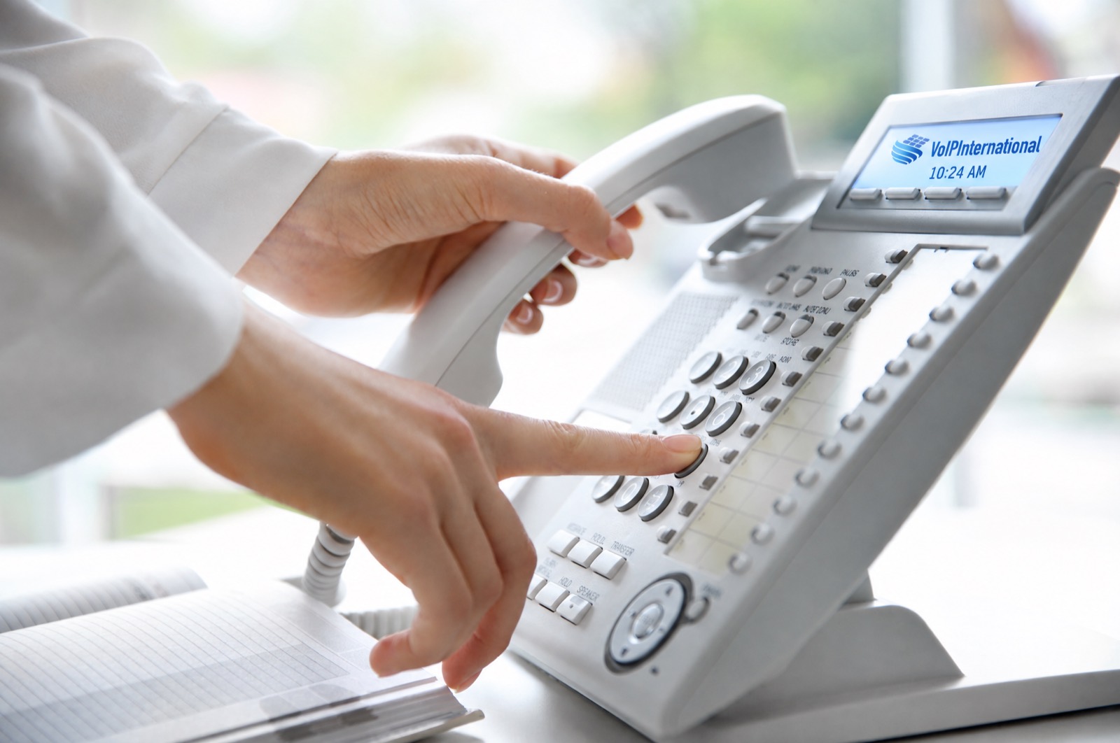 Hand dialing a white office phone