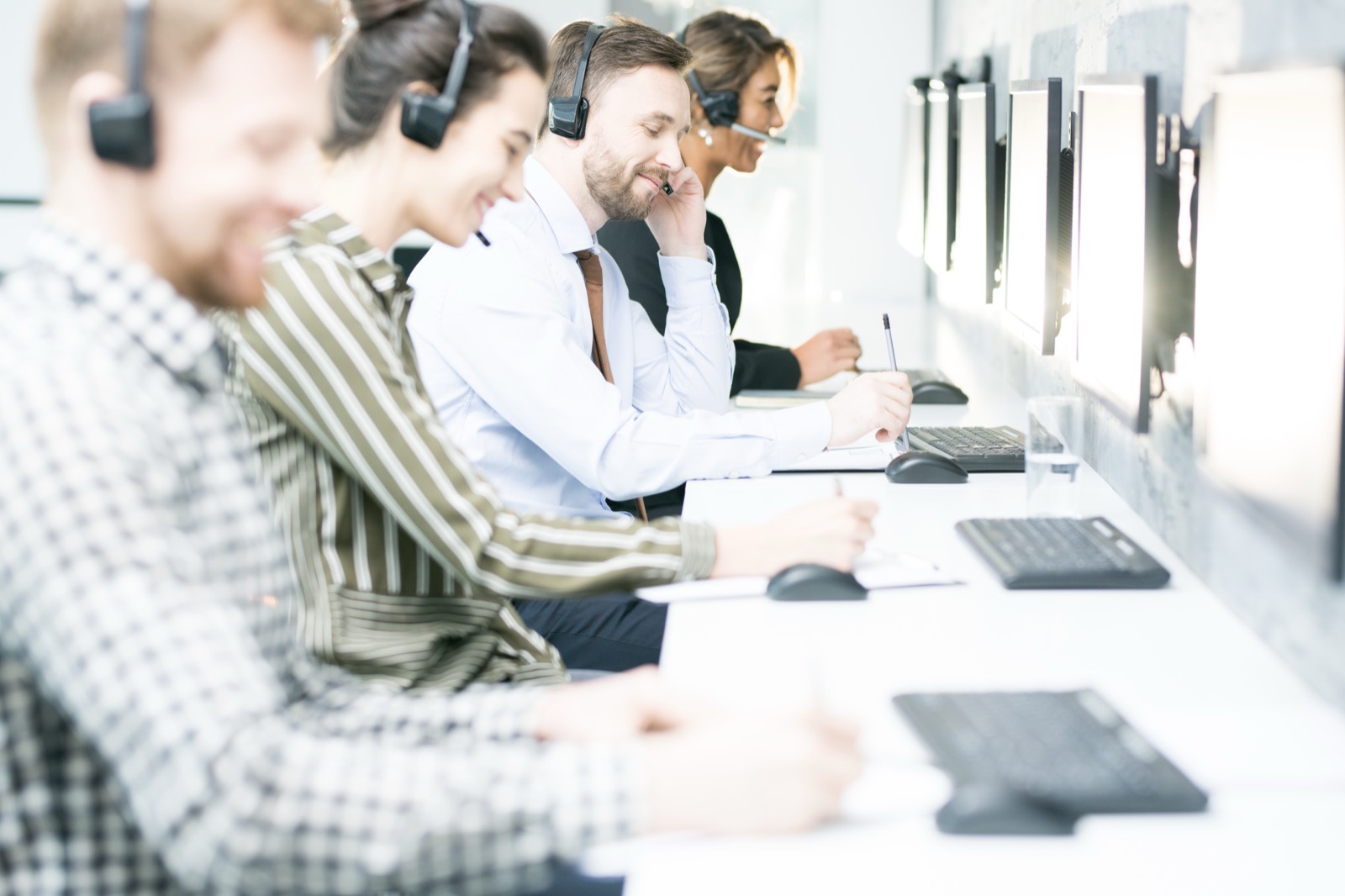 Agents on headsets in a bright office