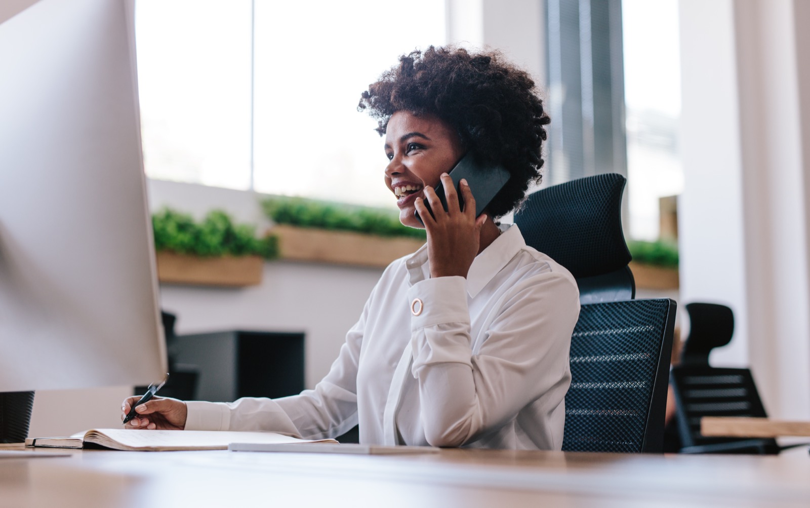 Office manager taking a call at her desk