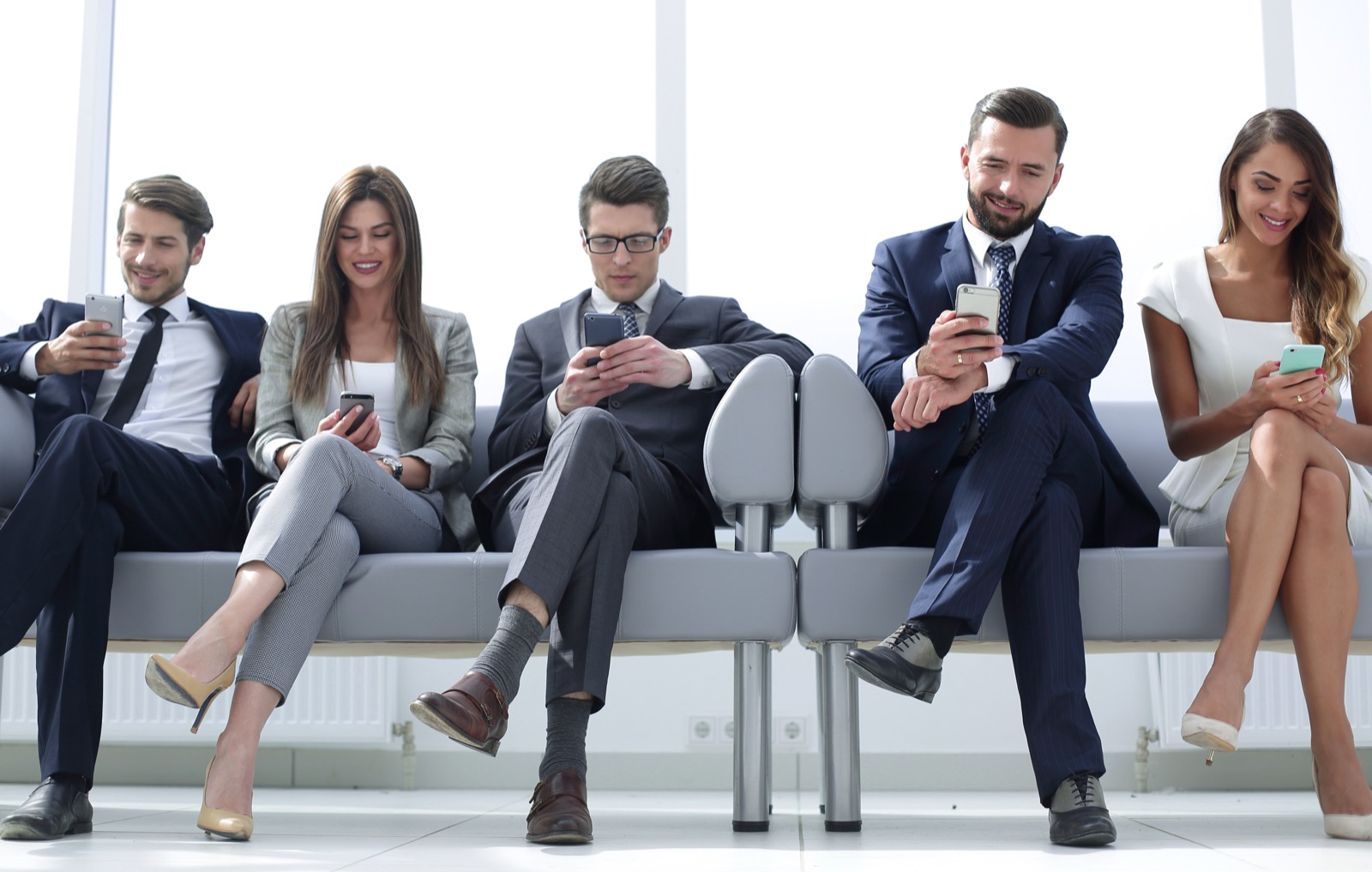 Professionals using their phones in a lobby